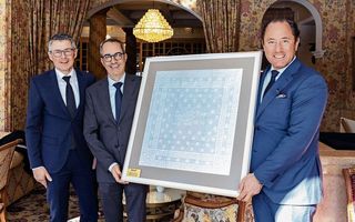 Manuel Küng und Patrik Locatelli von der Schwob AG überreichen Hoteldirektor Heinz E. Hunkeler die 100-jährige Serviette des Kulm Hotel St. Moritz (v. l.).