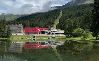 Rotes Bürogebäude an See und umgeben von Bäumen