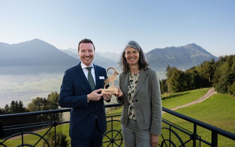 Anita Gschwind, Geschäftsführerin des Nachhaltigkeitslabel Ibex Fairstay übergibt Philipp Tschumi, stellvertretender Hoteldirektor, den Ibex Fairstay Steinbock für das Hotel Villa Honegg.