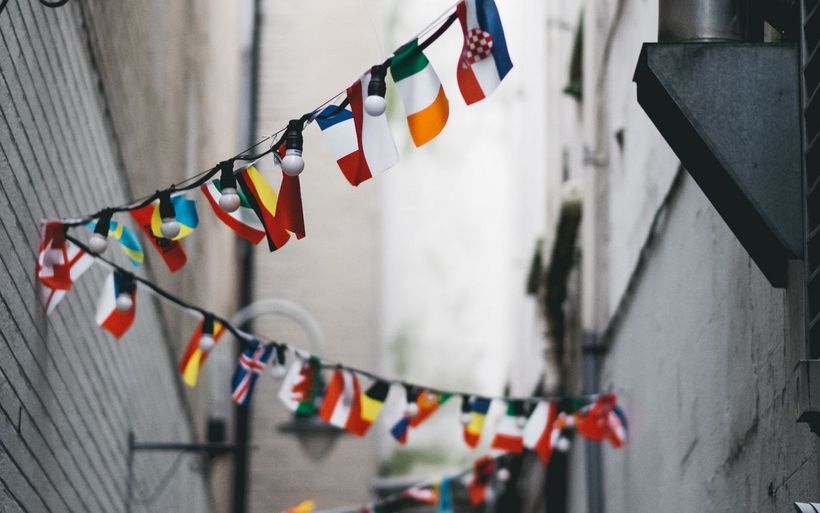 Länderflaggen wehen in einer Gasse.
