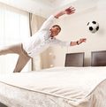 Mann im Hotelzimmer, der einen Ball fängt
