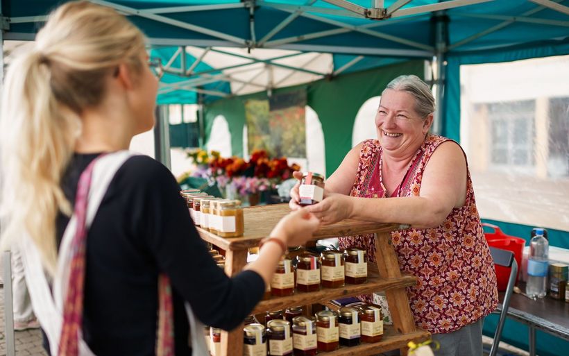 Ältere Frau verkauft Konfiture auf dem Markt