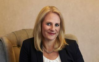 Frau mit blonden Haaren sitzt auf einem Sessel