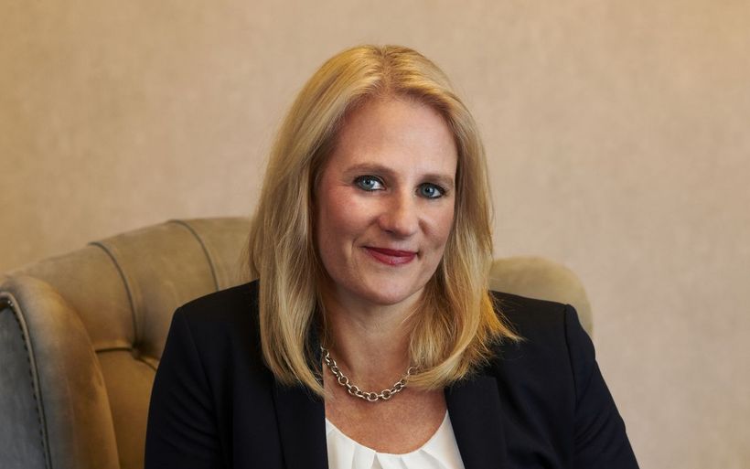 Frau mit blonden Haaren sitzt auf einem Sessel